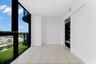 Floor-to-ceiling windows, wood-finish flooring, and a built-in closet with sliding doors