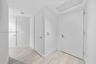 Interior space featuring neutral wall paint, wood-finish flooring, solid-core doors with satin-finish hardware, and recessed ceiling lighting