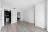 Room featuring wood-finish flooring, built-in closet cabinetry, and a vanity with a vessel sink