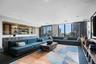 Expansive room featuring floor-to-ceiling windows, custom built-in dark wood cabinetry, recessed lighting, and integrated shelving units