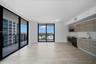 Modern kitchen featuring wood-finish cabinetry, stainless steel appliances, and integrated faucet fixtures, complemented by tile flooring and floor-to