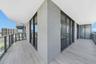 Wraparound balcony featuring tile flooring, metal railings, and floor-to-ceiling glass sliding doors