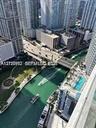 High-rise exterior balcony perspective featuring a swimming pool, waterfront access to the canal, and urban skyline surroundings