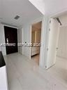 Entry foyer featuring high-gloss tile flooring, solid dark-wood entry door, and recessed lighting