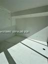 Large-format neutral tile flooring paired with clean white walls and recessed ceiling lighting