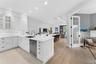 Kitchen featuring white shaker-style cabinetry, quartz countertops, a stainless steel dishwasher, recessed lighting, and wood-finish flooring