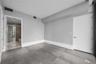 Interior room featuring large-format grey tile flooring, neutral wall tones, recessed linear ceiling lighting, and solid-core interior doors
