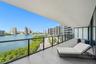 Expansive covered balcony featuring large-format porcelain tile flooring and a black metal railing with glass inserts