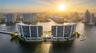 Waterfront high-rise complex situated on a peninsula, featuring multiple balconies, a swimming pool, and hardscaped recreational grounds