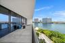 Expansive covered terrace featuring large-format tile flooring and full-height black-framed glass sliding doors