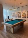 Modern linear pendant lighting, wood-finish flooring, and floor-to-ceiling window treatments