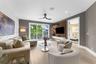 Living area featuring wood-finish flooring, a built-in media wall with wood paneling, floating cabinetry, recessed lighting, and sliding glass doors