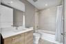 Bathroom featuring a vanity with a light wood-finish cabinet and solid-surface countertop, a rectangular undermount sink, recessed ceiling lighting, a