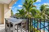 Covered balcony featuring a decorative metal railing, concrete flooring, and water frontage