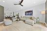 Open-concept interior featuring light-toned wood-finish flooring, recessed lighting, track lighting, and a contemporary three-blade ceiling fan