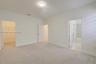 Neutral-toned carpeting, flush-mount ceiling lighting, interior panel doors, and walk-in storage space