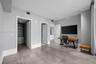 Large-format tile flooring, recessed ceiling lighting, and a walk-in closet featuring built-in shelving and integrated cabinetry