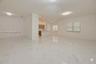Open-concept interior featuring large-format tile flooring with veined detailing, recessed ceiling lighting, decorative flush-mount fixtures, and wind