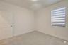 Neutral interior space featuring carpeted flooring, a paneled interior door, and a horizontal banded roller shade