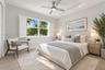Light-filled room featuring wood-finish flooring, plantation shutters, track lighting, and a brushed metal ceiling fan