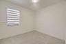 Neutral-toned wall paint, plush carpeting, ceiling-mounted light fixture, and dual-layer privacy window shades