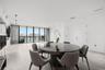 Open-concept interior featuring large-format tile flooring, floor-to-ceiling glass panel windows, integrated recessed lighting, and a private balcony