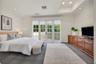 Spacious room featuring a recessed ceiling, grid-patterned glass French doors, built-in wooden cabinetry, recessed lighting, and patterned flooring
