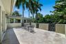 Expansive upper patio stone-paved terrace featuring solid masonry perimeter walls and decorative wrought-iron railing accents