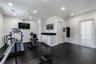Interior space featuring recessed lighting, a ceiling fan, matte-finish flooring, built-in cabinetry with a stone countertop, and a glass-paneled exte