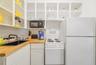 Kitchen featuring white cabinetry with open shelving, wood-finish countertops, an undermount sink with a matte black faucet, and white appliances
