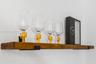 Wall-mounted floating wood shelf featuring a stained finish and matte black metal support brackets