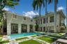 Two-story residence featuring a rectangular swimming pool, integrated covered loggias, ornamental iron balcony railings, stone-paver decking with turf