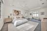 Spacious room featuring a recessed tray ceiling, white multi-blade ceiling fan, integrated recessed lighting, grid-pattern windows, and multi-light Fr