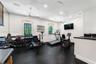 Room featuring durable rubberized flooring, recessed lighting, dual ceiling fans, multi-pane windows, and built-in cabinetry with a countertop and sin