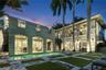 Exterior featuring a pool with stone hardscaping, recessed covered loggias, two-story balconies with ornate metal railings, and a built-in outdoor gri