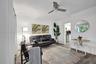 Living area featuring wood-finish flooring, a neutral color palette, and a modern ceiling fan with integrated lighting