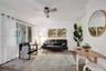 Living area featuring neutral wall paint, wood-finish flooring, crown molding, and a modern ceiling fan