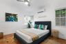 Room featuring terra-cotta tile flooring with decorative inlay accents, multi-pane windows with integrated blinds, ceiling fan, and wall-mounted clima