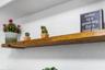 Wall-mounted solid wood floating shelving with matte black metal hardware brackets
