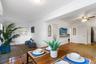 Interior space featuring terra cotta tile flooring, crown molding, a ceiling fan with integrated lighting, and a wall-mounted display shelf