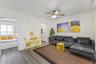 Living area featuring wood-finish flooring, a ceiling fan with integrated lighting, and a recessed wall niche