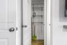 Storage closet featuring white paneled interior doors, round polished hardware, and adjustable wire shelving systems