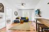 Terra-cotta tile flooring with decorative accent inlays, crown molding, built-in wall niche, and ceiling fan with integrated lighting