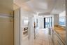 Kitchen featuring recessed lighting, stone countertops, integrated cabinetry, white appliances, and ceramic tile flooring