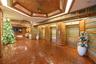 Lobby entrance featuring hexagonal wood-paneled ceilings with recessed accent lighting, metallic-finish elevator doors, and horizontal wood wall panel