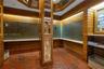 Mailroom area featuring horizontal wood paneling, terracotta tile flooring, built-in metal mailboxes, integrated task lighting, and a central column w