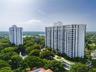 High-rise residential towers surrounded by mature trees, landscaped grounds, pedestrian walkways, and a decorative water feature