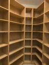 Floor-to-ceiling wooden shelving with a custom L-shaped configuration