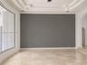 Interior space featuring multi-tiered tray ceiling, large-format polished stone flooring, expansive floor-to-ceiling windows, recessed lighting, and a
