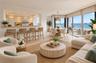 Open-concept living space featuring tile flooring, a kitchen breakfast bar with stone-surface countertop, recessed ceiling lighting, and floor-to-ceil